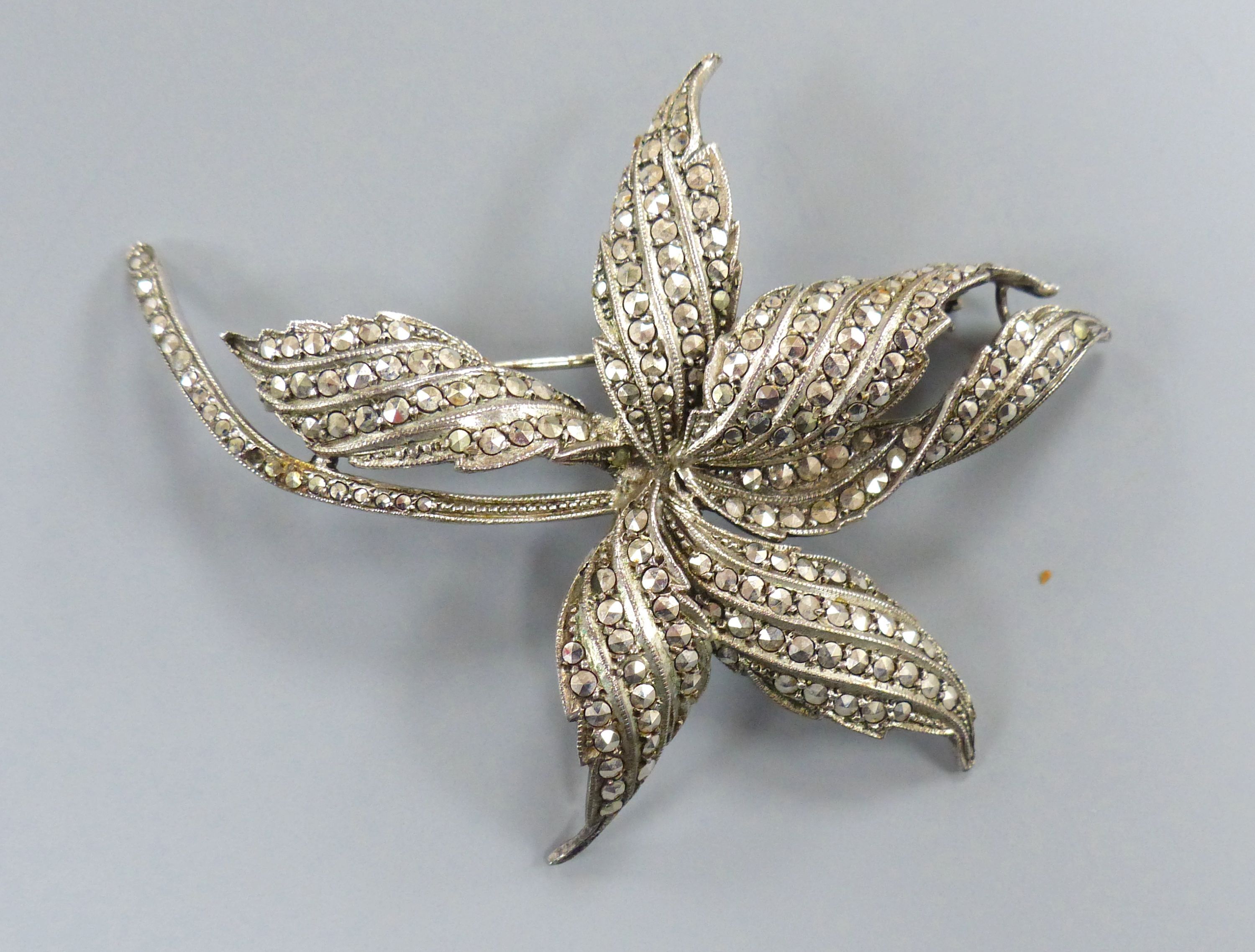 A 1960's silver and marcasite floral spray brooch and a lady's silver and marcasite wrist watch.